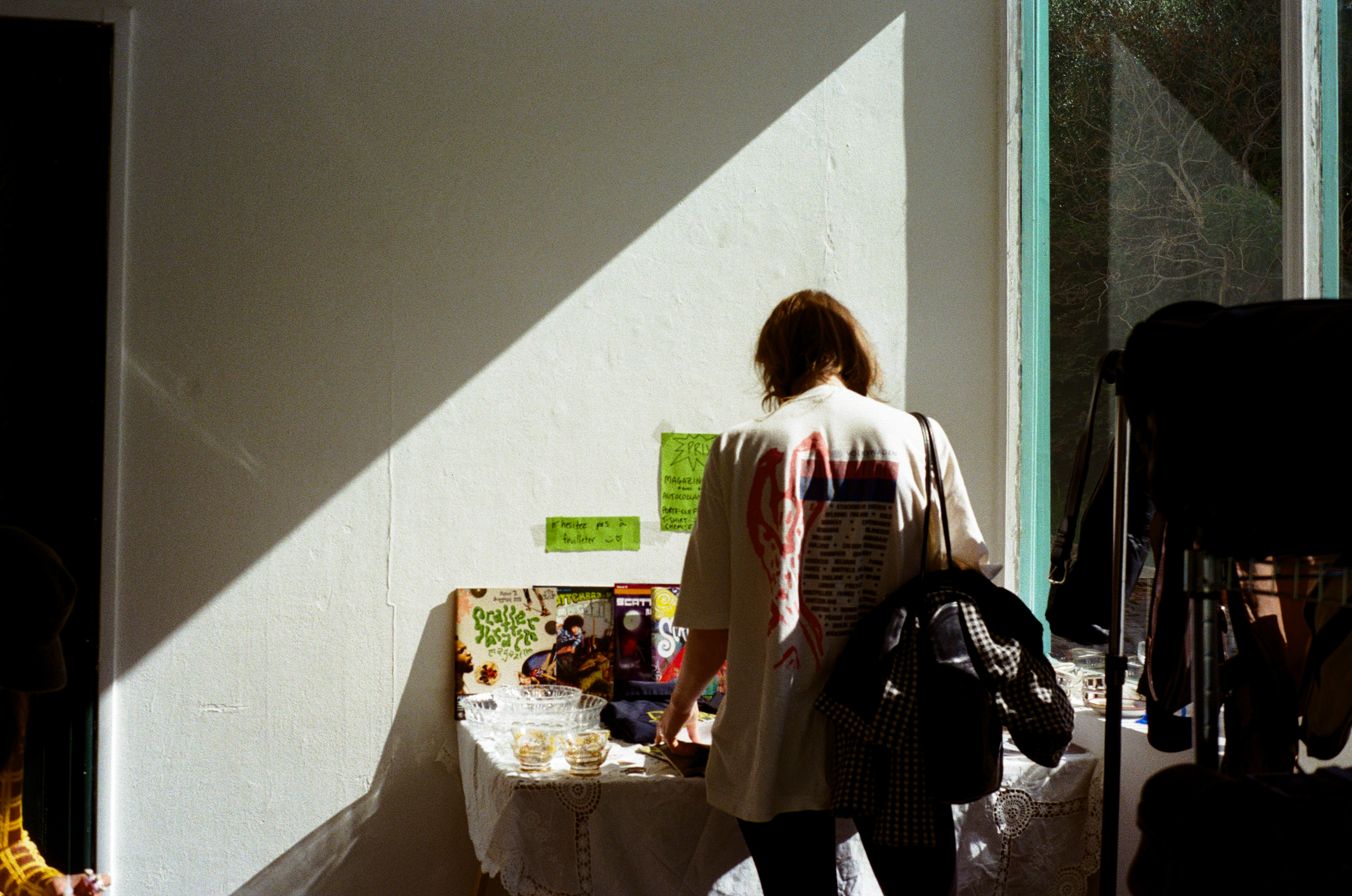 A visitor at the Scatterbrain Magazine table at the Floréal Belleville pop-up